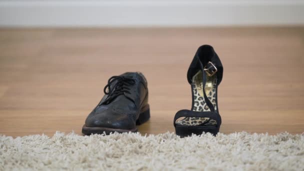 Κοντινό πλάνο αγνώριστων ξυπόλητων Καυκάσιων ανδρών που περπατούν στο παρασκήνιο και παίρνουν γυναικεία ψηλοτάκουνα παπούτσια. Ενήλικο intersex άτομο που επιλέγει την ταυτότητα μεταξύ ανδρών και γυναικών. — Αρχείο Βίντεο