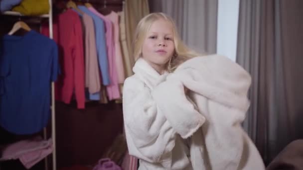 Câmera se aproximando para encantadora menina caucasiana secando o cabelo com toalha. Retrato de criança sorrindo descansando em seu quarto nos fins de semana. Alegria, higiene, lazer . — Vídeo de Stock