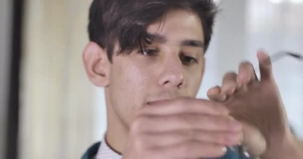 Detailní záběr sebevědomého mladíka, jak si nasazuje brýle. Portrét pohledného studenta mužské univerzity. Cinema 4k Prores Hq. — Stock video