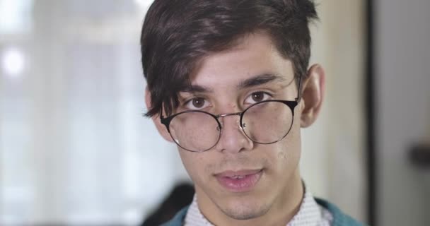 Portrait of handsome confident Caucasian man with brown eyes looking at camera. Close-up of young brunette guy adjusting eyeglasses. Cinema 4k ProRes HQ. — 비디오