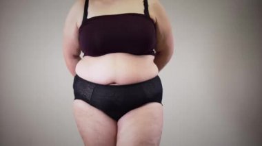 Unrecognizable obese Caucasian woman measuring hips. Fat girl in underwear having obesity and overweight problem. Unhealthy lifestyle, overeating.