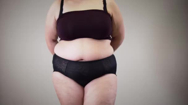 Donna caucasica obesa irriconoscibile che misura i fianchi. Ragazza grassa in biancheria intima con obesità e problemi di sovrappeso. Stile di vita malsano, eccesso di cibo . — Video Stock