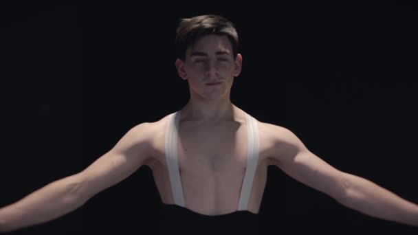 Ballet professionnel blanc masculin danseur filant et souriant dans l'obscurité. Bel homme confiant dansant la danse classique. Chorégraphie, élégance, art. Slowmo . — Video