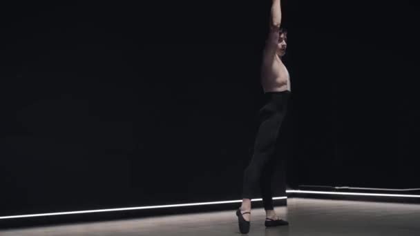 Retrato de bailarina de ballet caucásica profesional saltando, girando en el aire, y de pie sobre una rodilla. Joven confiado bailando danza clásica en la luz del escenario. Movimiento lento . — Vídeo de stock