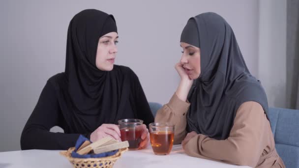 La modesta donna musulmana in hijab sta calmando la sua amica dall'aspetto moderno. Giovane signora confortante e abbracciare piangendo amico. Amicizia, comunicazione, supporto . — Video Stock
