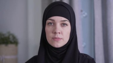 Geleneksel siyah tesettürlü güzel Müslüman kadının yakın plan portresi. Çekici bayan kameraya bakıyor. Güzellik, tarz, kültür, yaşam tarzı.