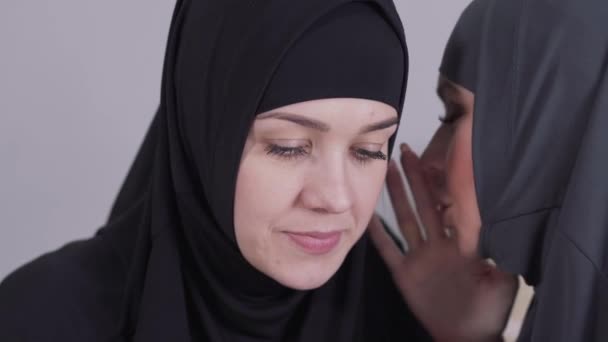 Nahaufnahme einer schockierten und überraschten muslimischen Frau, die Klatsch und Tratsch hört. zwei erwachsene Frauen aus dem Osten unterhalten sich drinnen. Klatsch, Freundschaft, Kommunikation. — Stockvideo