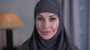 Türbanlı gri gözlü, modern görünümlü bir kadının yakın plan portresi. Kendine güvenen genç bayan kameraya bakıyor ve gülümsüyor. Yaşam tarzı, kültür, güzellik.