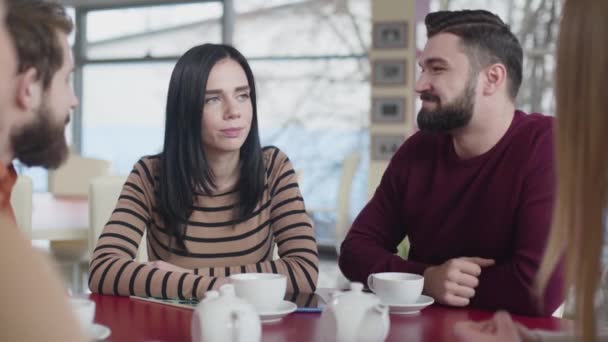 Portrait of young Caucasian couple in love hugging in cafe. Happy man and woman sitting with friends in restaurant on weekends. Lifestyle, joy, happiness, leisure. — Stok video