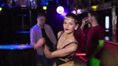 Young seductive Caucasian woman dancing and showing invite gesture at camera. Portrait of pretty confident girl in night club. Lifestyle, leisure, entertainment, joy.