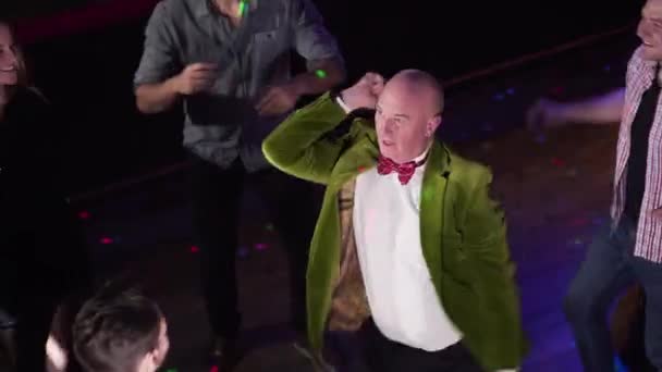 Top view of active funny dance of old Caucasian man in green jacket. Positive elderly guy resting in night club. Joy, lifestyle, fun. — Stockvideo