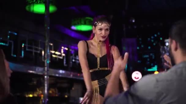Positive Caucasian woman with red hair dancing on stage and smiling to visitors. Professional young go go dancer working in night club. Profession, occupation, lifestyle. — Stockvideo