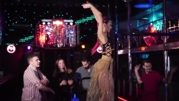 Fiatal magabiztos kaukázusi pizsama táncol a színpadon az éjszakai klubban. Egy gyönyörű nő portréja tetovált kézzel és vörös hajjal a színpadon. Életmód, foglalkozás, szórakozás. — Stock videók