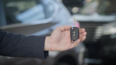 Yetişkin beyaz bir kadının araba anahtarlarını alışı yakın plan. Satıcılıktaki tanınmayan üst düzey müşteriye yeni otomobil satan bir tüccar. Otomobil endüstrisi, yaşam tarzı, başarı.