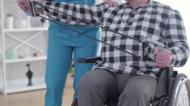 Tanımlanamayan bayanın elastik bant esnemesi ve bakım evindeki hasta. Engellilerin fizyoterapisi, rehabilitasyon, engelli konsepti.