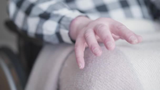 Nahaufnahme von reifen kaukasischen Palmenschütteln. Der behinderte Rentner hält die Hand auf Knien, bedeckt mit einer Decke. Invalidität, Rente, medizinische Versorgung, Lebensstil. — Stockvideo