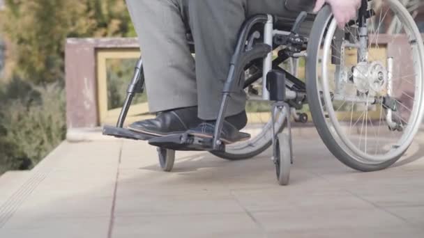 Vista lateral primer plano de la silla de ruedas con un anciano irreconocible rodando a las escaleras. Concepto de disponibilidad de rampa, desafíos de discapacidad, estilo de vida . — Vídeos de Stock