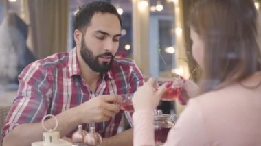 Kafeteryada Kafkasyalı kız arkadaşıyla tartışan Orta Doğulu bir adamın portresi. Sinirli genç yakışıklı erkek arkadaş restoranda esmer kadınla tartışıyor. İletişim sorunları, çatışma.