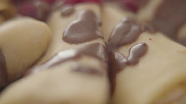 Çikolata soslu aşırı yakın plan tatlı krep. Lezzetli pastanenin etrafında kamera yavaşça sağa sola hareket ediyor. Yemek, beslenme, tatlı, Shrove Salı.