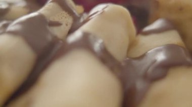 Fırınlanmış kreplerin yakın çekimi hızlı sola ve sağa doğru gidiyor. Çikolata soslu ve tabağında böğürtlen olan lezzetli tatlı. Shrovetide, Shrove Salı, yemek, yemek.