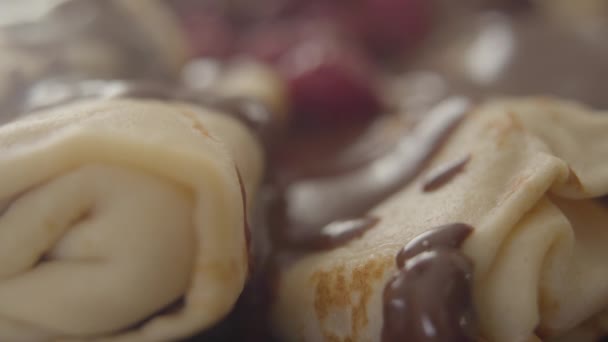 Close-up de cobertura de chocolate pingando em panquecas assadas. Sobremesa doce saborosa com bagas e xarope deitado no prato. Shrove terça-feira, comida, cozinhar, padaria . — Vídeo de Stock