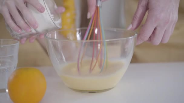 Close-up van vrouwelijke blanke handen slaan eieren als weinig onherkenbaar meisje gieten bloem in kom. Grootmoeder en kleindochter koken pannenkoeken voor Shrove Tuesday in de keuken. Bakken, Shrovetide. — Stockvideo