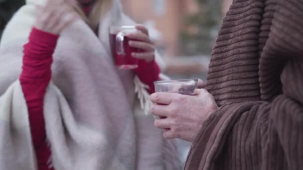 Hombre y mujer mayores irreconocibles de pie al aire libre con tazas de té. Caucásico jubilado charlando con su pariente. Ocio, estilo de vida, relajación . — Vídeos de Stock