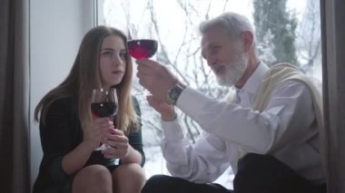 Yakışıklı, olgun, beyaz bir adamın portresi. Genç, zarif bir bayana şarap tatma notlarını açıklıyor. Gri saçlı şarap garsonu güzel bir bayanla eğleniyor. Aşk, eğlence, yaş farkı..