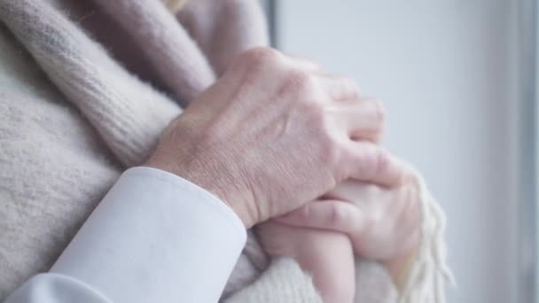 Primo piano di mani caucasiche maschili anziane che accarezzano giovani palme femminili. Coppia amorevole con differenza di età trascorrere del tempo insieme in casa. Unità, stile di vita, amore, tempo libero . — Video Stock