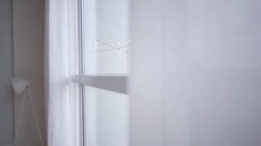 Esmer, genç bir kadının sabahları pencereye gelip esneme hareketleri. Büyüleyici beyaz kız evde uyanıyor. Neşe, yaşam tarzı, uyanış..