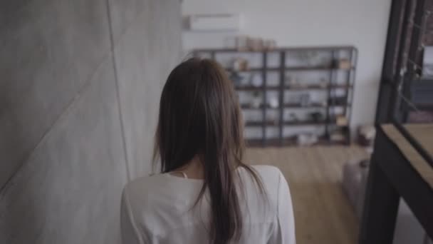 Vue arrière de la jeune brune femme caucasienne qui descend les escaliers à l'intérieur. Fille confiante dans le corps blanc passer la matinée à la maison le week-end. Joie, style de vie, loisirs, élégance . — Video