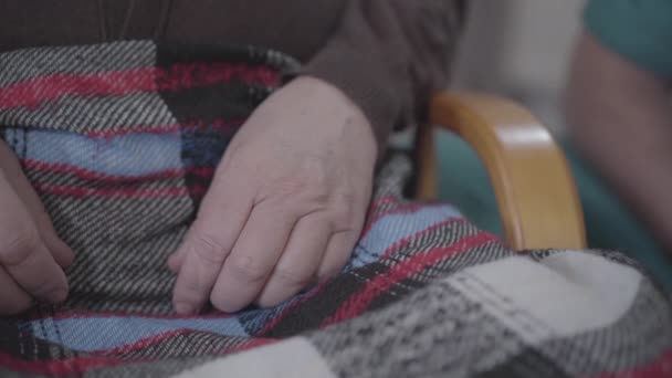Extreme Nahaufnahme einer männlichen kaukasischen Hand, die eine ältere Handfläche einnimmt. Bis zur Unkenntlichkeit erwachsene Krankenschwester in Arbeitskleidung unterstützt Rentner im Pflegeheim. Hilfe, Altern, Lebensstil, Freiwilligenarbeit. — Stockvideo