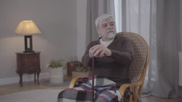 Retrato del infeliz viejo caucásico con bastón mirando a un lado y suspirando. Deprimido jubilado mayor tocando la cara y hablando consigo mismo. Soledad, envejecimiento, estilo de vida, desesperación . — Vídeos de Stock