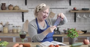 Selfie makinesine çırpı ve şarap kadehiyle poz veren kıdemli beyaz kadın portresi. Olgun emeklinin akıllı telefondan video görüşmesi yapması. Sinema 4k ProRes Merkezi.