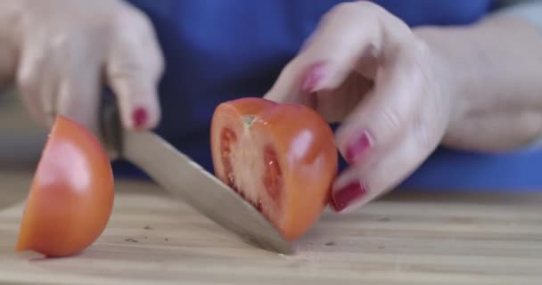 Extremo close-up de mãos caucasianas femininas cortando tomate com faca de cozinha. Mulher idosa irreconhecível preparando alimentos vegetarianos orgânicos frescos. Cozinhar, culinária, culinária. Cinema 4k ProRes HQ . — Vídeo de Stock