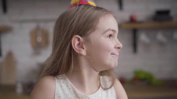 Lento, close-up retrato de menina morena caucasiana alegre com rosto sujo com doces mascar bolo. Criança pequena alegre com olhos castanhos se divertindo na festa de aniversário. Movimento lento . — Vídeo de Stock