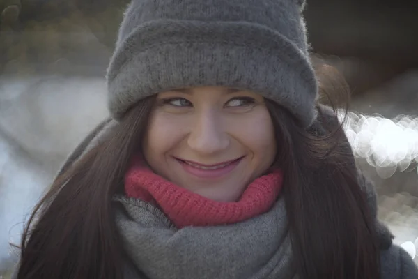 Lähikuva muotokuva iloinen tyttö ovela hymy sivuun. Iloinen brunette nuori nainen poseeraa ulkona puistossa. Hauskuus, vapaa-aika, elämäntapa . — kuvapankkivalokuva