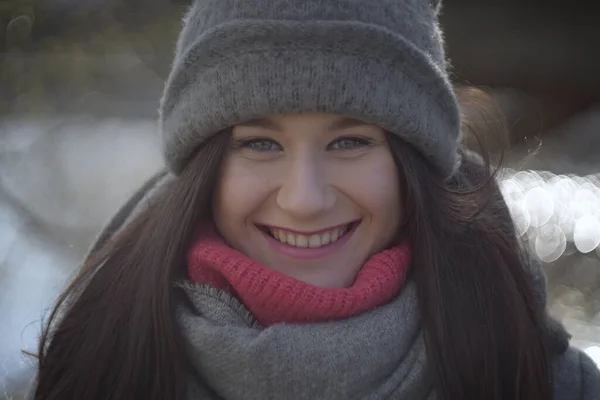 Et nært portrett av lykkelig brunette-jente med toothy smil foran kamera. En lykkelig ung kvinne med grå øyne som poserer utendørs. Fritid, glede, lykke, livsstil . – stockfoto