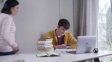 Kafkasyalı katı bir anne, genç oğluna ders çalışıp akıllı telefonu elinden alıyor. Ebeveyn, çocuğu online sörf yapmak yerine ders çalışmaya zorluyor. Yaşam tarzı, eğitim, sosyal medya, dikkat dağınıklığı.