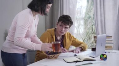 Kafkasyalı özenli anne, masada sıkı çalışan genç çocuğa çay ve tatlı getiriyor. Esmer kadın, ödev yapan zeki oğluyla ilgileniyor. Üniversite, yaşam tarzı, eğitim, destek.