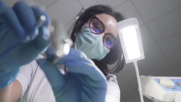 Detailní dolní pohled portrét ženského bělošského stomatologa s manipulačními nástroji. Zubní lékařství, stomatologie, medicína, odontologie. — Stock video