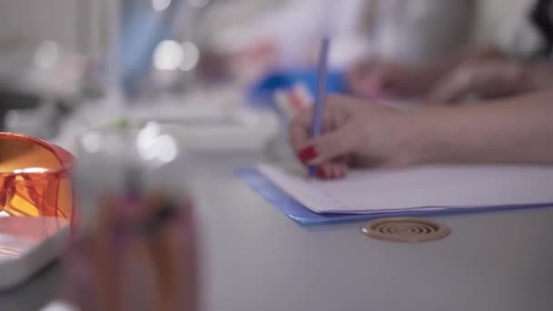 El enfoque cambia de modelo de dientes a mano caucásica femenina escribiendo una conferencia. Estudiantes irreconocibles estudiando odontología. Medicina, salud, educación, profesión . — Vídeos de Stock