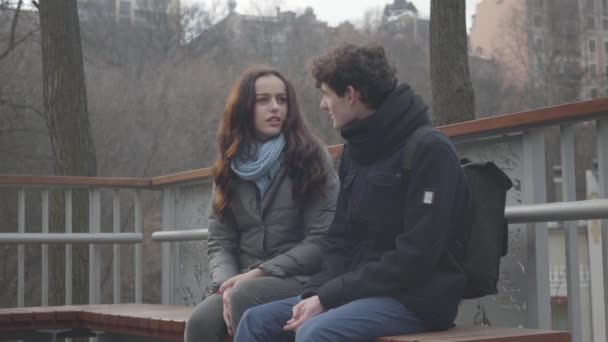 Retrato de menina branca bonito sorrindo como namorado consertando seu cabelo ao ar livre. Feliz encantadora jovem namoro com menino estudante do sexo masculino no parque. Amor, romance, união, união . — Vídeo de Stock