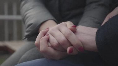 Beyaz erkek ve kadınların el ele tutuşup yakınlaştığı yakın plan. Tanımlanamayan genç bir adam ve kadın avuçlarını okşuyor. Birlik, aşk, romantizm, evlilik kavramı.