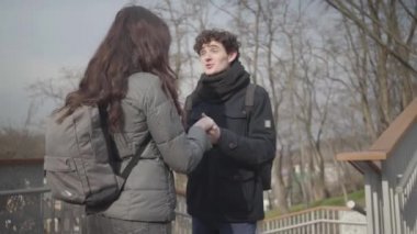 Kamera, güneşli sonbahar parkında kız arkadaşıyla konuşan mutlu beyaz çocuktan uzaklaşıyor. Mutlu esmer adam, aşkla kıza bakıyor. Romantizm, yaşam tarzı, birliktelik..