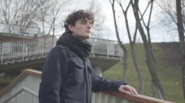 Sonbahar parkında iç çekip giden yalnız beyaz bir çocuğun portresi. Mutsuz genç esmer adam güneşli bir günü dışarıda yalnız geçiriyor. Üzüntü, yalnızlık, yalnızlık, yaşam tarzı..