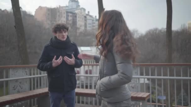 Linda chica caucásica abrazando novio gritando en el parque de otoño. Pareja joven haciendo las paces después del conflicto al aire libre. Amor, dificultades de relación, solución . — Vídeos de Stock