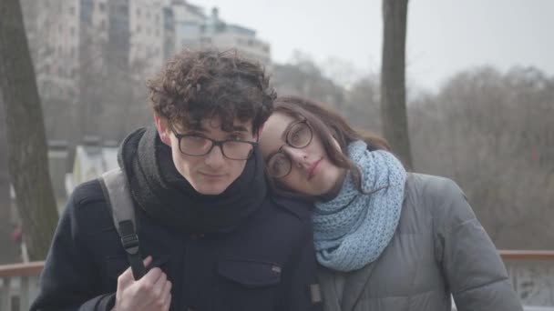 Divertido caucásico morena chico mirando a la cámara como posando con bonita novia al aire libre. Retrato de feliz pareja joven citas en el parque de otoño y sonriendo. Amor, estilo de vida, romance, diversión . — Vídeo de stock