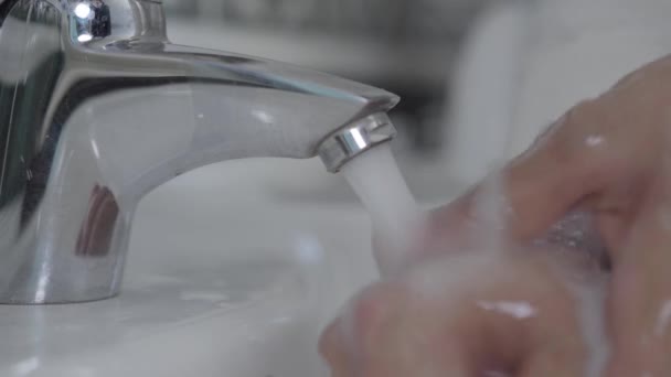 Extreme close-up van mannelijke handen die zeep afwassen en water afzetten. Onherkenbare bewuste man die handpalmen grondig schoonmaakt op quarantaine. Covid-19, gezondheidszorg, pandemisch virus. — Stockvideo