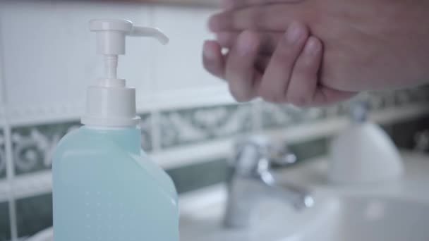Close-up van desinfecterende handen met handreiniger. Mannelijke palmen die vloeistof aanbrengen in de badkamer tijdens coronavirus quarantaine. Gezondheidszorg, geneeskunde, Covid-19, isolatie, hygiëne. — Stockvideo